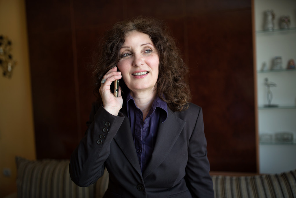 professional woman in business attire smiling confidently, office background
